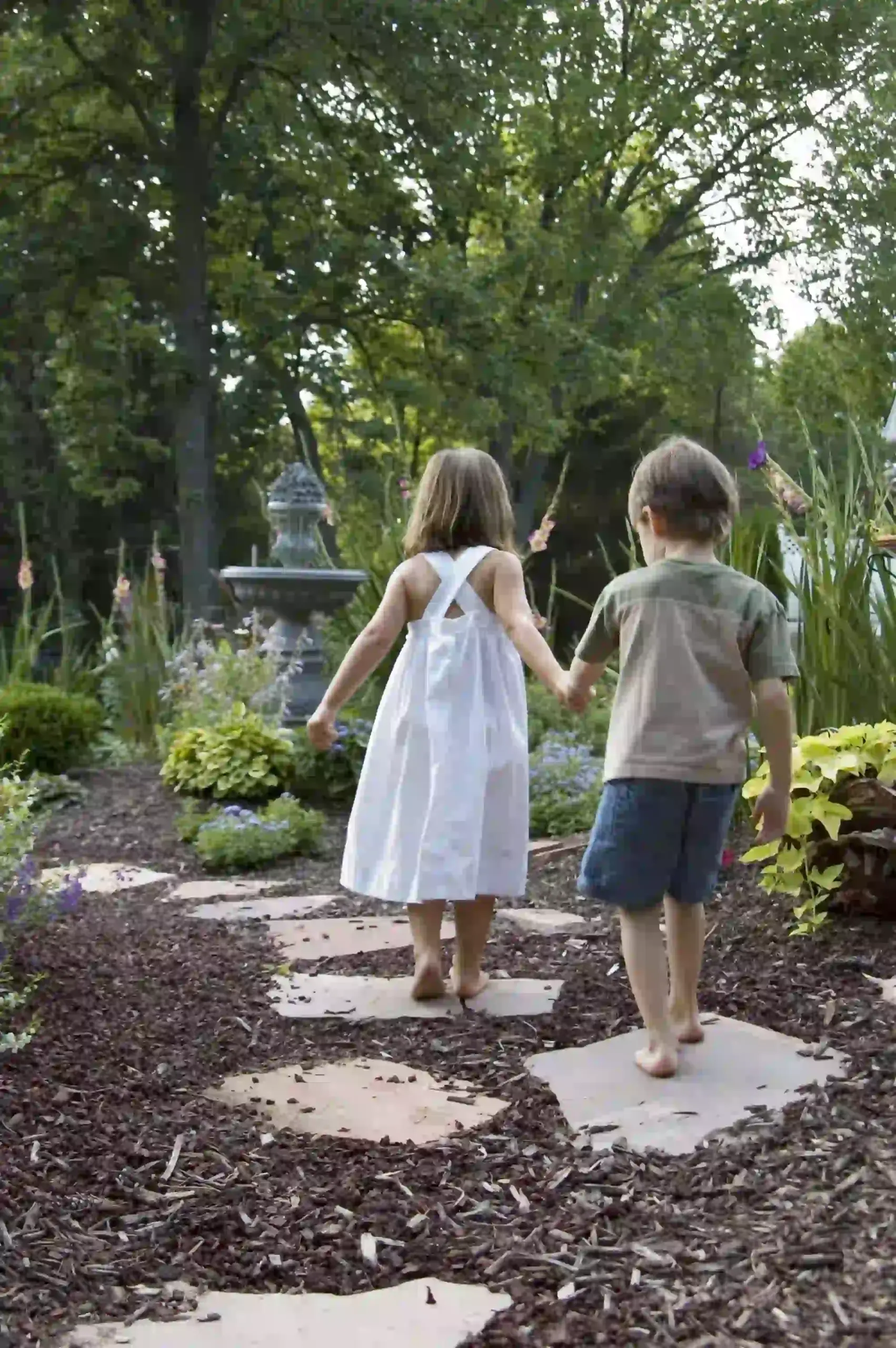 Children holding hands while walking on nature path